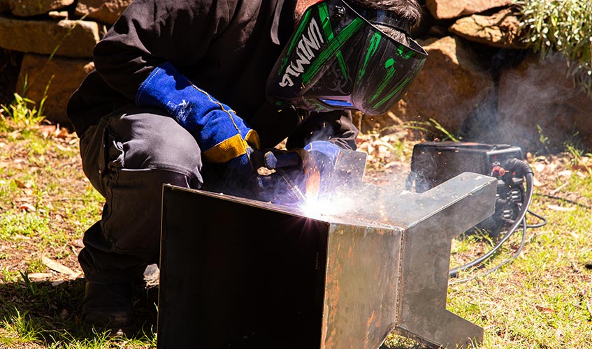 Viper 120 welding flux-cored wire outdoors on a firepit