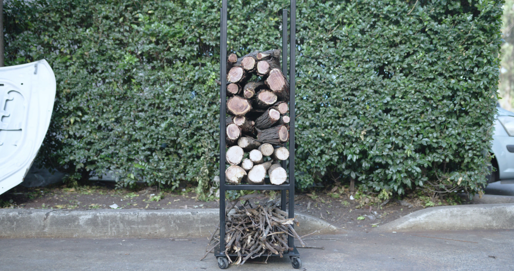 Finished DIY firewood rack filled with logs and kindling