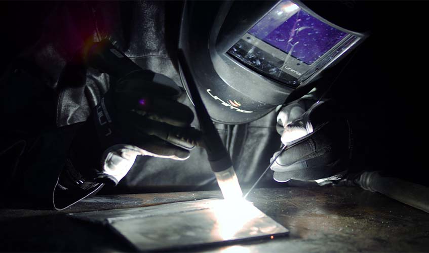 A welder completing a high frequency TIG weld on a mild steel butt joint